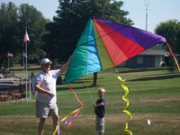Largo back pain free grandpa and grandson playing with a kite